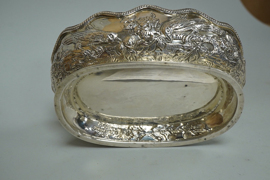 A late Victorian embossed silver oval bowl, decorated with birds, fruit and foliage, Charles Stuart Harris, London, 1889, length 14.3cm, 5.6oz.